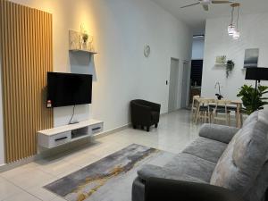 uma sala de estar com um sofá e uma televisão de ecrã plano em SSR312/S2TOWN/3R2B HOMESTAY em Seremban
