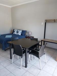 una sala da pranzo con tavolo, sedie e letto di 13 Steps a Springbok