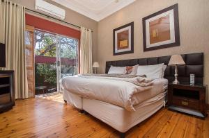 a bedroom with a large bed and a large window at Saffron Guest House in Johannesburg