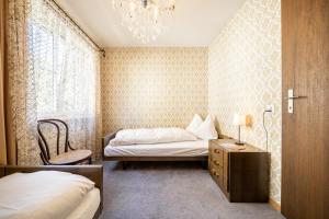 een slaapkamer met 2 bedden en een kroonluchter bij 7202 Zweckmaessig eingerichteten Wohnung mit gedecktem Balkon in Vulpera