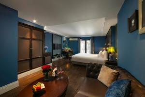 a living room with a bed and a couch at O'Gallery Premier Hotel & Spa in Hanoi