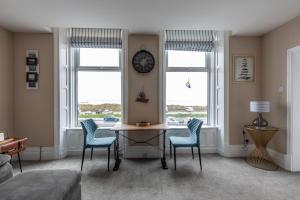 a living room with a table and chairs and a clock at BEACH VIEW - Amazing Sea Views in Lytham St Annes