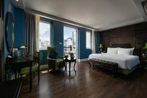 una camera d'albergo con letto, scrivania e finestre di O'Gallery Premier Hotel & Spa a Hanoi