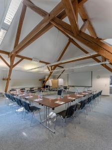 uma grande sala de conferências com uma mesa longa e cadeiras em Hotel An der Wasserburg em Wolfsburg