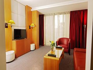 a hotel room with a television and a red chair at WH Hotel in Beirut