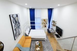 uma sala de estar com uma cama e uma televisão em 75-A New stylish Loft 1BR W D Prime Upper east em Nova York