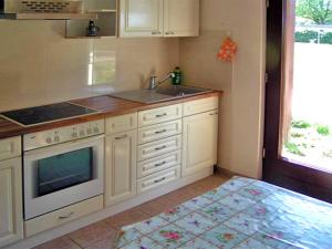 a kitchen with white cabinets and a sink and a stove at Apartment Tina in Ahrenshagen