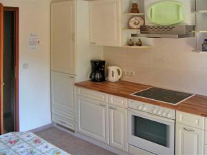 a kitchen with white cabinets and a stove top oven at Apartment Tina in Ahrenshagen