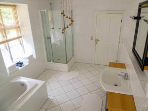 a white bathroom with a shower and a sink at Gutshaus Jülchendorf in Jülchendorf