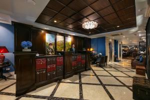 um bar no saguão de um hotel com um homem em pé no balcão em O'Gallery Premier Hotel & Spa em Hanói