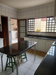 una cucina con tavolo nero e lavandino di Aero Hostel a Londrina