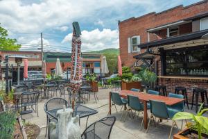 a patio with tables and chairs and a umbrella at Cherry Street Loft (B) Pet-Friendly & In the Heart of Downtown Black Mtn! in Black Mountain