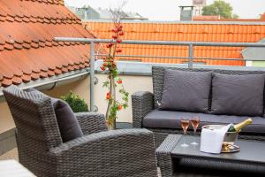 eine Terrasse mit 2 Stühlen und einem Tisch mit Weingläsern in der Unterkunft Hotel Kronprinz in Greifswald