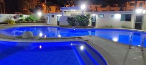 una piscina por la noche con una casa en el fondo en Torres Sobrium 2 habitaciones Sleep 6, en Tonsupa