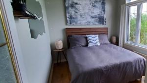 um quarto com uma cama e uma janela em Waterfront Oasis Luxury Retreat Between Ottawa and Montreal em Hawkesbury