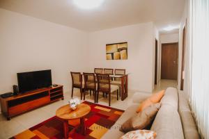 Confortável apartamento na Savassi. في بيلو هوريزونتي: غرفة معيشة مع أريكة وتلفزيون وطاولة