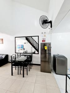 a dining room with a table and a refrigerator at Vacation Transient Guest House Rental Calapan City L43 in Calapan
