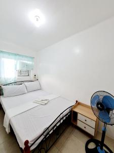a bedroom with a bed with a fan and a desk at Vacation Transient Guest House Rental Calapan City L43 in Calapan