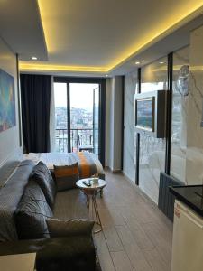 Habitación de hotel con cama, sofá y TV en Taksim Larissa hotel suites, en Estambul