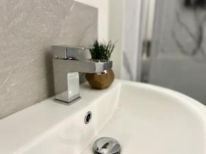 a bathroom sink with a faucet on top of it at Gloucester Serviced Apartments in Gloucester