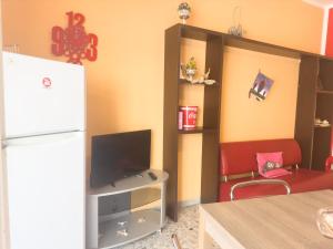 a kitchen with a refrigerator and a red chair at Azzurramare, centralissimo in Pescara