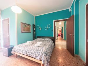 a bedroom with blue walls and a bed with two towels at Azzurramare, centralissimo in Pescara