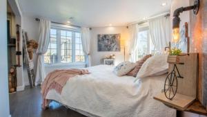 um quarto com uma cama grande com lençóis brancos e almofadas em Waterfront Oasis Luxury Retreat Between Ottawa and Montreal em Hawkesbury