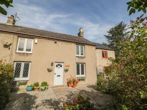 a house with a white door and some plants at Croft Cottage in Castleton