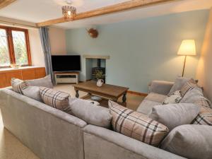 a living room with a couch and a tv at Croft Cottage in Castleton