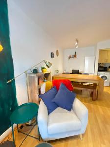a living room with a white chair and a table at Cosy Modern Apartment in Portobello in Dublin