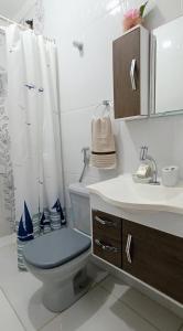 La salle de bains est pourvue de toilettes et d'un lavabo. dans l'établissement Casa da Lú - Praia e Piscina, à Praia Grande