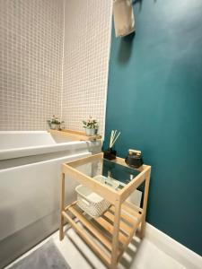 a bathroom with a blue wall and a tub and a table at Cosy Modern Apartment in Portobello in Dublin