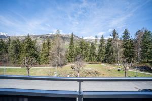 a view from a window of a field and trees at PL 202 Lichtdurchflutete Wohnung mit grossem Balkon Richtung Scuol in Vulpera