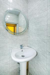 ein Badezimmer mit einem weißen Waschbecken und einem Spiegel in der Unterkunft Qız Qalası 2 room Sweet Home in Baku