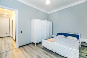 ein Schlafzimmer mit einem weißen Bett und einem Schrank in der Unterkunft Qız Qalası 2 room Sweet Home in Baku