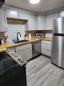 a kitchen with white cabinets and a stainless steel refrigerator at MOMA Your Historic Stay in Springfield