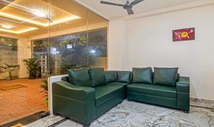 a green couch in a living room with a ceiling at Treebo Trend Navya The Park in Hyderabad