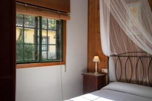 a bedroom with a bed and a window at Casa Rural Pontevedra con piscinajardínbarbacoa in Pontevedra +99 photos