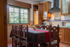 a kitchen with a table and chairs in a kitchen at Casa Rural Pontevedra con piscinajardínbarbacoa in Pontevedra