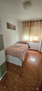 1 dormitorio con cama y ventana en Piso Granada 3 dormitorios y parking privado, en Granada