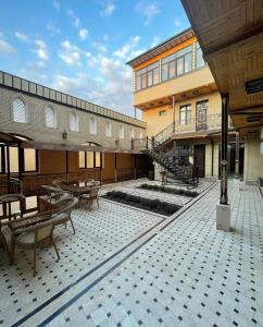 un patio con mesas y sillas en un edificio en VOSTOK HOTEL en Bukhara