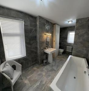a large bathroom with a tub and a sink at Castle View House in Clitheroe