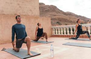 un grupo de personas en una clase de yoga en Riad Les Roches Todra, en Tinerhir