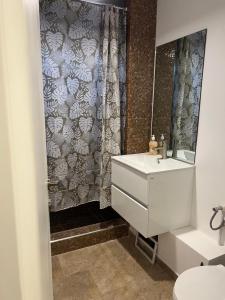 a bathroom with a white sink and a shower at Green Apartament in Bacău