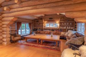 a living room with a table in a log cabin at Chalet De Luxe 518 in Trysil