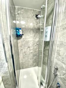 a bathroom with a shower with a glass door at One Bed Studio with Free private Car Park in London in London