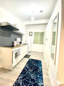 a kitchen with a stove and a kitchen rug at One Bed Studio with Free private Car Park in London in London