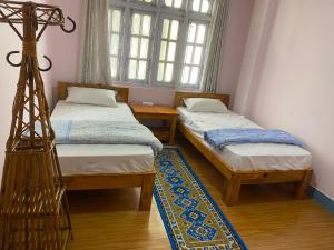 een kamer met 2 aparte bedden en een raam bij Himalayan Vacation Home in Kathmandu