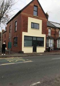 a person on a skateboard in front of a brick building at Ninian Park Road in Cardiff