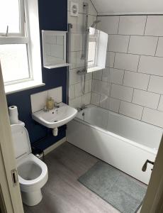 a bathroom with a toilet and a tub and a sink at Ninian Park Road in Cardiff